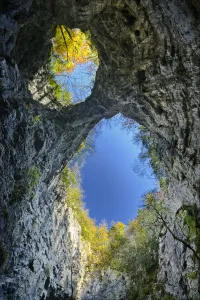 Looking up at the sky through the twin openings in a collapsed cave ceiling, Zelske Jame Looking up at the sky through the twin openings in a collapsed cave ceiling, Zelske Jame