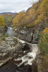 River Tromie flowing through gorge in autumn woodland. Cairngorms National Park, Scotland River Tromie flowing through gorge in autumn woodland. Cairngorms National Park, Scotland