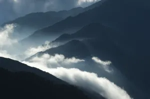 Upcoming clouds over forest covered mountains Upcoming clouds over forest covered mountains