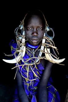 Young girl in traditional dress. Mursi tribe, Mago National Park. Omo Valley, Ethiopia Young girl in traditional dress. Mursi tribe, Mago National Park. Omo Valley, Ethiopia