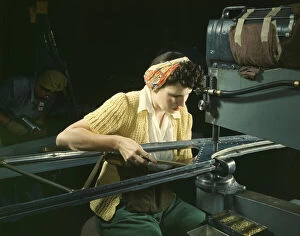 Alfred Palmer Collection: A girl riveting machine operator at the Douglas Aircraft Company plant... Long Beach, Calif