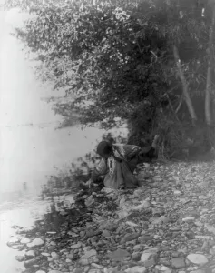 Indigenous People USA Prints: By the river-Flathead, c1910. Creator: Edward Sheriff Curtis