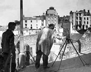 An artist painting the harbour in Tenby An artist painting the harbour in Tenby