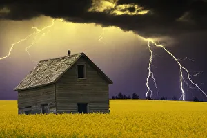 An Abandoned Farm Building With Lighting In The Background An Abandoned Farm Building With Lighting In The Background
