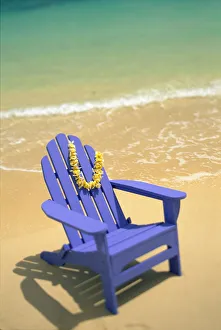 Blue Chair Along Shoreline With Plumeria Lei Hanging On Side Blue Chair Along Shoreline With Plumeria Lei Hanging On Side