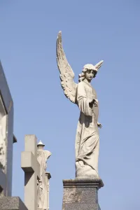Buenos Aires, Argentina; Angel Statues And A Cross Made Of Stone On Top Of Tombs Buenos Aires, Argentina; Angel Statues And A Cross Made Of Stone On Top Of Tombs