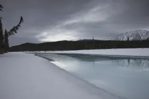 Dark Winter Evening On The Athabasca River In The Canadian Rockies, Jasper National Park, Alberta Dark Winter Evening On The Athabasca River In The Canadian Rockies, Jasper National Park, Alberta