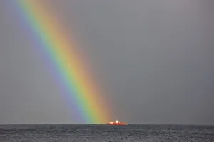 Dunoon, Argyll, Scotland; Rainbow Leading To A Boat On The Ocean Dunoon, Argyll, Scotland; Rainbow Leading To A Boat On The Ocean