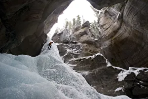 Female Ice Climber Rappels Into The Head Of Maligne Canyon In Jasper National Park, Alberta, Canada Female Ice Climber Rappels Into The Head Of Maligne Canyon In Jasper National Park, Alberta, Canada