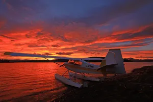 A Float Plane Facing The Sunrise Over Teslin Lake, Yukon A Float Plane Facing The Sunrise Over Teslin Lake, Yukon