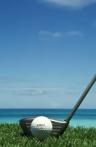 Golf Ball And Driver, Ocean In Blurred Background Golf Ball And Driver, Ocean In Blurred Background