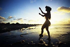 Hawaii, Female Hula Dancer On Beach, Silhouetted By Sunset Hawaii, Female Hula Dancer On Beach, Silhouetted By Sunset