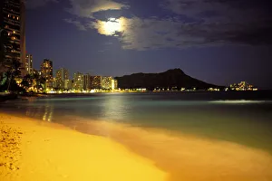 Hawaii, Oahu, Diamond Head At Night, Moon Hidden Behind Clouds, Bright Yellow Sand Skyline Illuminated Hawaii, Oahu, Diamond Head At Night, Moon Hidden Behind Clouds, Bright Yellow Sand Skyline Illuminated