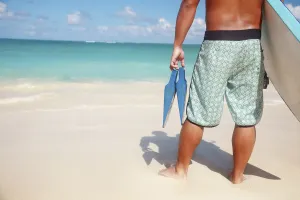 Hawaii, Oahu, Local Male Holding A Bodyboard And Fins At The Beach, View From Behind Hawaii, Oahu, Local Male Holding A Bodyboard And Fins At The Beach, View From Behind