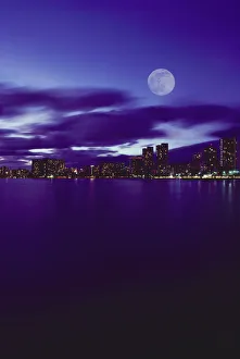 Hawaii, Oahu, Waikiki City Lights With Large Full Moon, Pale Purple Sky With Reflections On Water Hawaii, Oahu, Waikiki City Lights With Large Full Moon, Pale Purple Sky With Reflections On Water