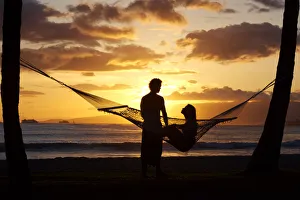 Hawaii, Oahu, Waikiki, Kapiolani Park, Silhouette Of Woman In Hammock And Man Standing Next To Her Hawaii, Oahu, Waikiki, Kapiolani Park, Silhouette Of Woman In Hammock And Man Standing Next To Her