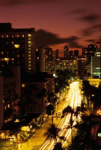 Hawaii, Waikiki, Overview Of Palm Lined Kalakaua Avenue Lit Up At Dusk Hawaii, Waikiki, Overview Of Palm Lined Kalakaua Avenue Lit Up At Dusk