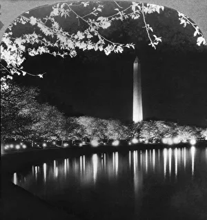 Historic image in black and white of the Washington Monument illuminated at nighttime and reflected in a river Historic image in black and white of the Washington Monument illuminated at nighttime and reflected in a river