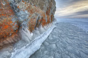 Large lichen covered rock in a frozen lake situated on the flats beside hudson's bay; Manitoba canada Large lichen covered rock in a frozen lake situated on the flats beside hudson's bay; Manitoba canada