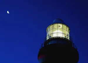 Moon Crescent Above Lighthouse At Dusk, Low Angle View, Close Up Moon Crescent Above Lighthouse At Dusk, Low Angle View, Close Up