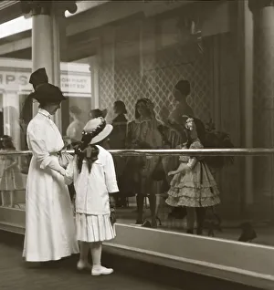 Mother and daughter looking in shop window in Victorian or Edwardian era in sepia tone Mother and daughter looking in shop window in Victorian or Edwardian era in sepia tone