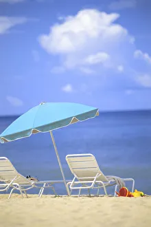 Pair Of Beach Chairs And An Umbrella On White Sand Beach With Blue Skies And Water Pair Of Beach Chairs And An Umbrella On White Sand Beach With Blue Skies And Water