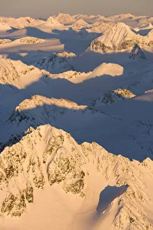Peaks Of A Snow Covered Mountain Range Glowing Pink At Sunset Peaks Of A Snow Covered Mountain Range Glowing Pink At Sunset