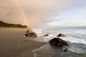 A Rainbow Glows In Storm Clouds Over A Beach And Coastline; Alaska, United States A Rainbow Glows In Storm Clouds Over A Beach And Coastline; Alaska, United States