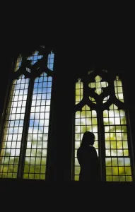 Silhouette Of A Girl Standing By A Stained Glass Window; Vancouver, British Columbia, Canada Silhouette Of A Girl Standing By A Stained Glass Window; Vancouver, British Columbia, Canada