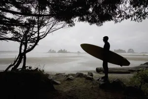 Silhouette Of A Surfer Looking Out To The Water From The Beach Silhouette Of A Surfer Looking Out To The Water From The Beach