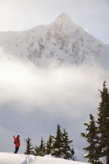 Snowboarder On A Ridge With Scenic Mountains And Fog In The Background, Haines, Southeast Snowboarder On A Ridge With Scenic Mountains And Fog In The Background, Haines, Southeast
