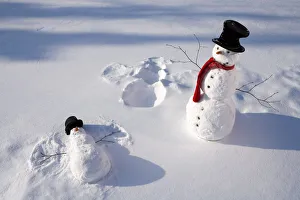 Snowmen In Forest Making Snow Angel Imprint In Snow In Late Afternoon Sunlight Alaska Winter Snowmen In Forest Making Snow Angel Imprint In Snow In Late Afternoon Sunlight Alaska Winter