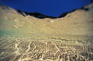 Underwater Reflections Along Sandy Bottom, At Surface Blue Sky Visible Underwater Reflections Along Sandy Bottom, At Surface Blue Sky Visible