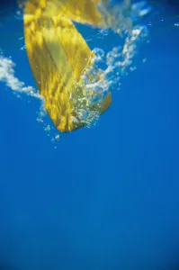 Underwater View Of Yellow Paddle Stroking Water, Creating Bubbles Underwater View Of Yellow Paddle Stroking Water, Creating Bubbles