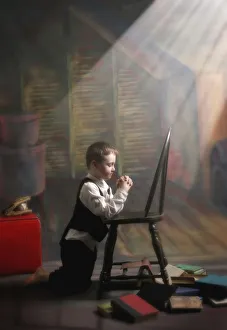 A Young Boy Praying With A Light Beam On Him; Victoria, British Columbia, Canada A Young Boy Praying With A Light Beam On Him; Victoria, British Columbia, Canada