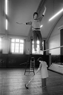 Actor Michael Crawford works out on the high wire with a charlady sweeping the floor Actor Michael Crawford works out on the high wire with a charlady sweeping the floor