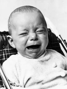 A baby crying as he sits in his high chair January 1973 A baby crying as he sits in his high chair January 1973