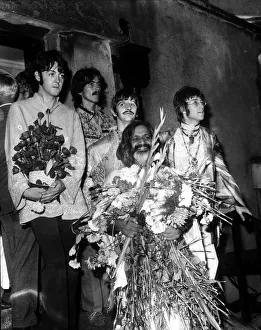 The Beatles with the Maharishi Mahesh Yogi who is clutching bundles of flowers Beatles The Beatles with the Maharishi Mahesh Yogi who is clutching bundles of flowers Beatles
