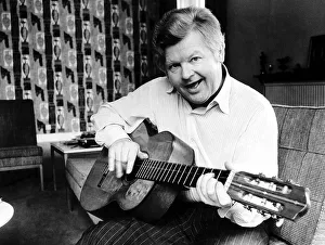 Benny Hill at home playing his guitar 1979 Benny Hill at home playing his guitar 1979