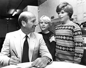 Bobby Charlton signs his autograph for David Laws (centre Bobby Charlton signs his autograph for David Laws (centre