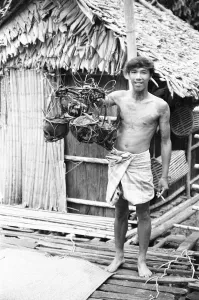 A Borneo headhunter tribesman seen here holding up a basket of human skulls A Borneo headhunter tribesman seen here holding up a basket of human skulls
