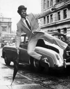 Boxer Sugar Ray Robinson doing an impression of Sammy Davis Junior dressed in a city Boxer Sugar Ray Robinson doing an impression of Sammy Davis Junior dressed in a city