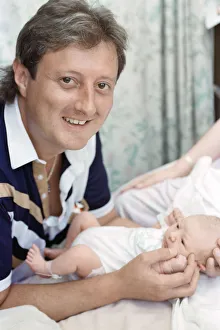 British darts player Eric Bristow poses at home with his new born baby girl who has been British darts player Eric Bristow poses at home with his new born baby girl who has been