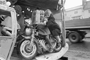 Brother and sister riding a motorcycle on a child's roundabout at the Northallerton Brother and sister riding a motorcycle on a child's roundabout at the Northallerton