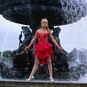 Carol Smillie model TV presenter wearing red dress standing ion front of a water fountain Carol Smillie model TV presenter wearing red dress standing ion front of a water fountain
