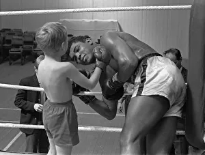 Cassius Clay with 6 year old Patrick Power in the ring during his training for Cassius Clay with 6 year old Patrick Power in the ring during his training for