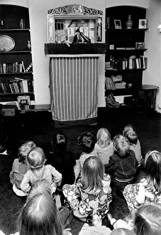 Children sitting on the floor watching the Pinch and Judy puppet show at a party Children sitting on the floor watching the Pinch and Judy puppet show at a party