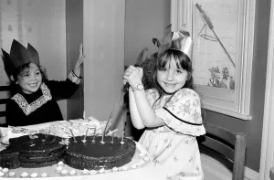 Childrens birthday party: The birthday girl cuts the cake. March 1981 PM 81-01186b Childrens birthday party: The birthday girl cuts the cake. March 1981 PM 81-01186b