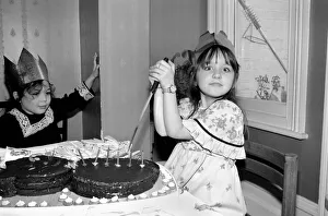 Childrens birthday party: The birthday girl cuts the cake. March 1981 PM 81-01186b-001 Childrens birthday party: The birthday girl cuts the cake. March 1981 PM 81-01186b-001