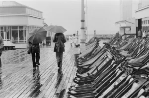 A couple walk along the deserted pier in Blackpool as the rain arrives to interrupt a A couple walk along the deserted pier in Blackpool as the rain arrives to interrupt a